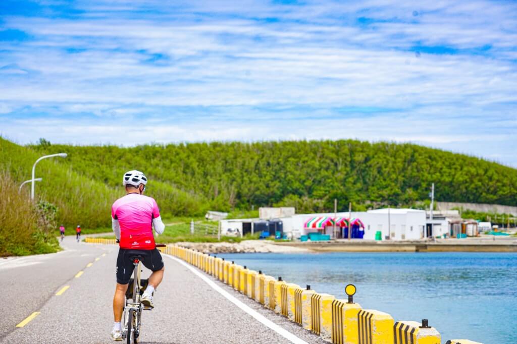 imgi_45_47589_PH_20250326_001 cyclist is riding on a scenic coastal road alongside the ocean,