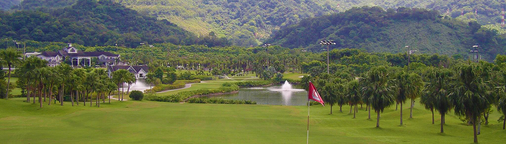 wide, scenic landscape featuring lush green fairways and rolling mountains