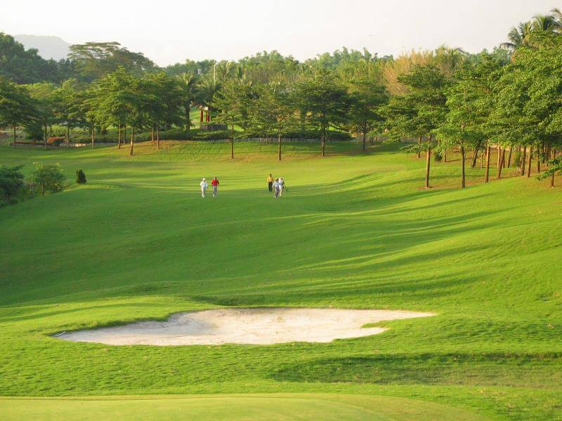 golf-hualien2 sunlit green golf course fairway with a white sand bunker