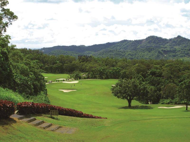 golf-kaohsiung-pt07 lush green golf course fairway surrounded by dense groves of trees