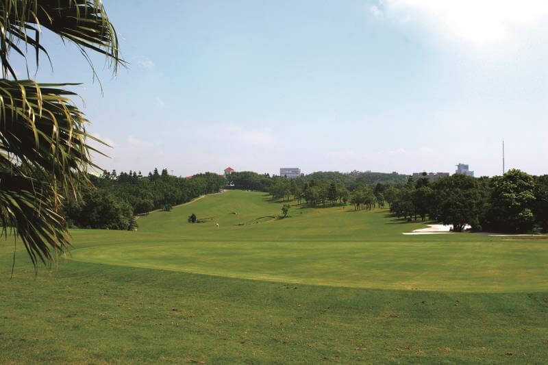 golf-taoyuan-14 gently undulating green fairway of the Chang Gung Golf Club under a partly cloudy sky
