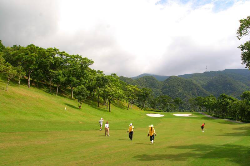 golf-yilan2 lush green golf course fairway nestled against a backdrop of heavily forested hills