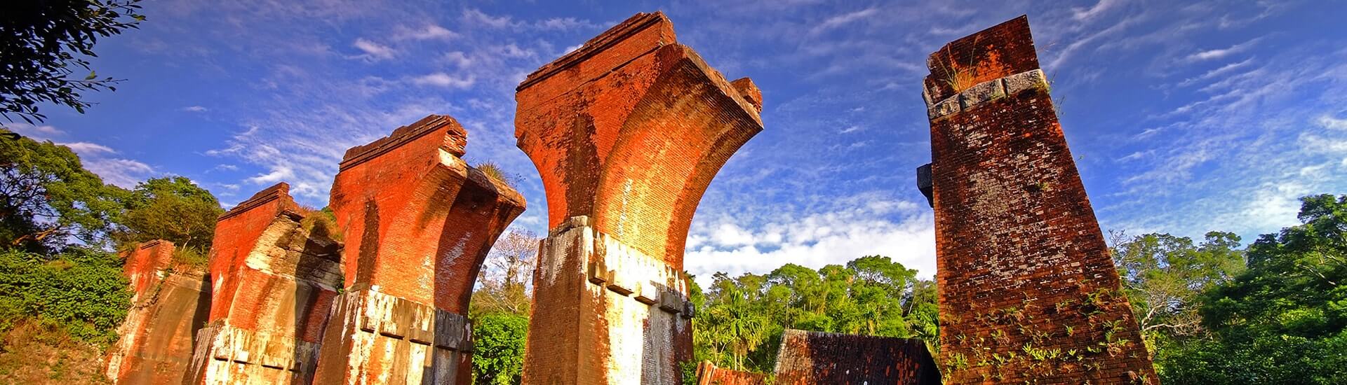Historic Miaoli temple facade nestled among rolling green hills in Taiwan.