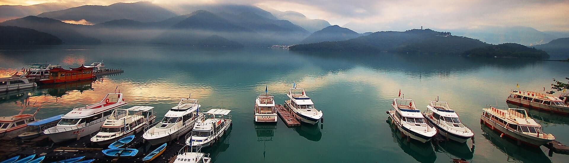 High-angle overview of Sun Moon Lake under clear blue skies in Nantou.