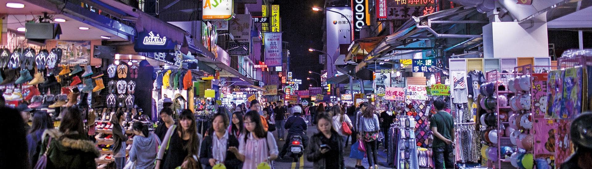 Panoramic night view of Taichung city illuminated by vibrant urban streetlights.