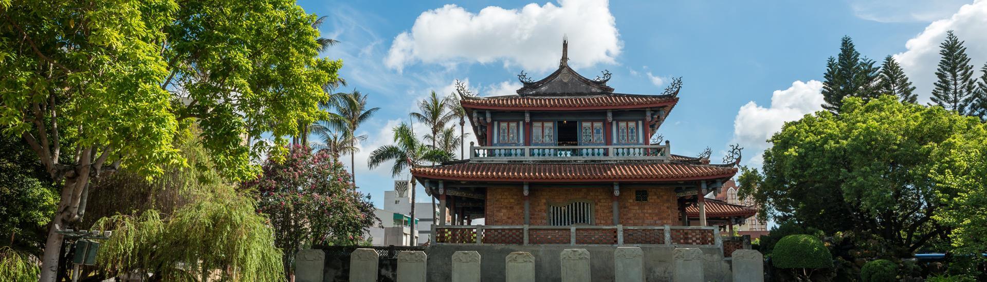 Traditional red courtyard temple building in historic Tainan under sunny skies.