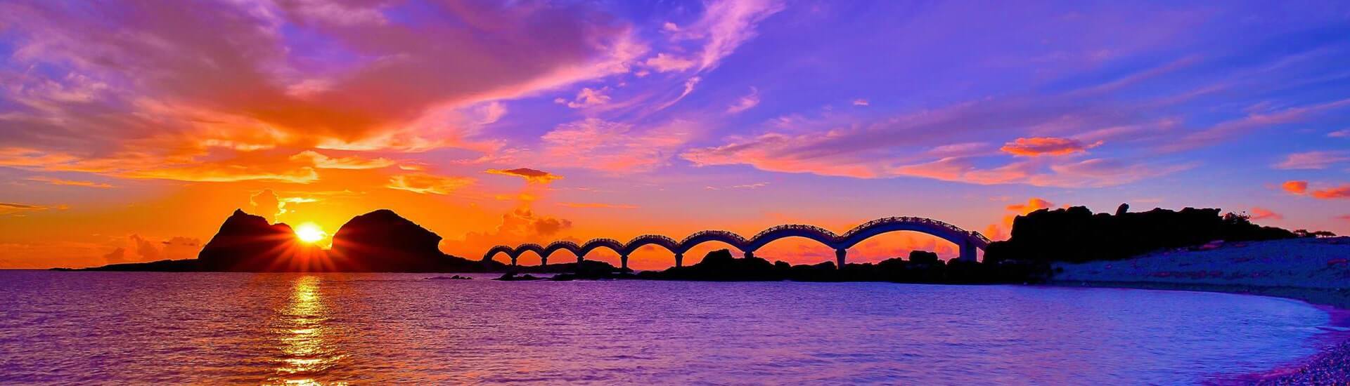 Vibrant sunrise reflecting over the Pacific Ocean shoreline in Taitung County.